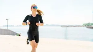 Un athlète débutant en triathlon sortant de l’eau, prêt à enchaîner avec le vélo et la course.