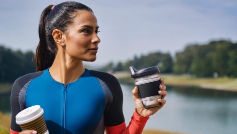 Triathlète énergique jonglant entre caféine et suppléments ergogéniques, prêt pour les défis de la natation, du cyclisme et de la course à pied